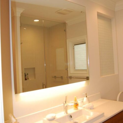 Backlit Frameless Vanity Mirror Set with Standoffs and Caps in Bathroom | Mirrors Gallery | Anchor-Ventana Glass