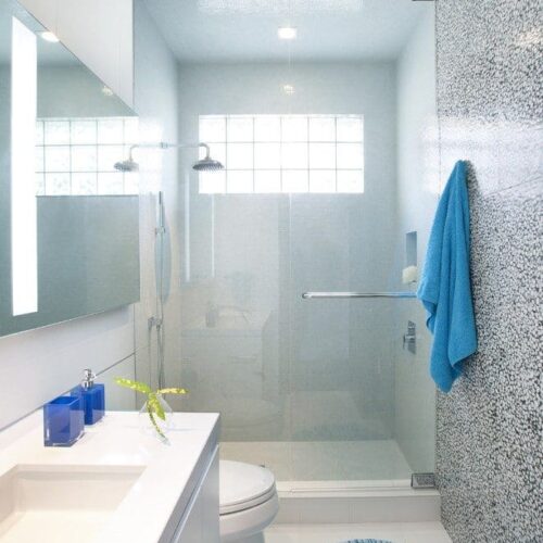 Bright contemporary bathroom with clear glass shower door and large mirror | Shower Gallery | Anchor-Ventana Glass Design